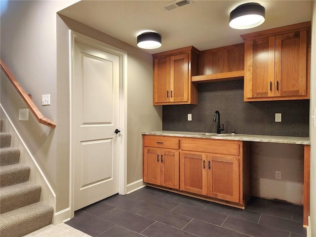 kitchen with sink, decorative backsplash, and dark tile patterned floors