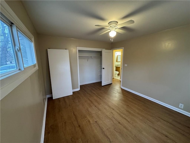 unfurnished bedroom featuring a closet, dark wood-style flooring, ceiling fan, and baseboards