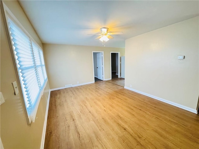 spare room featuring visible vents, ceiling fan, light wood-style flooring, and baseboards