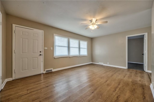 entrance foyer with visible vents, ceiling fan, baseboards, and wood finished floors