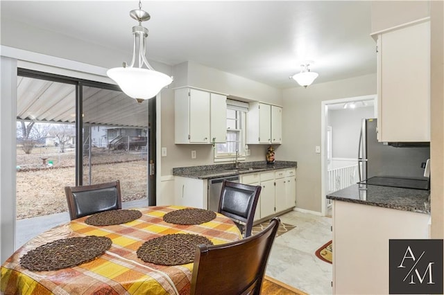 kitchen featuring hanging light fixtures, white cabinetry, appliances with stainless steel finishes, and sink