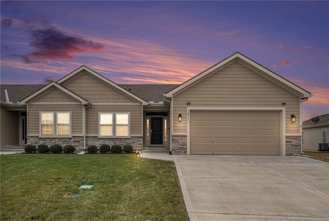 view of front of property featuring a garage and a lawn