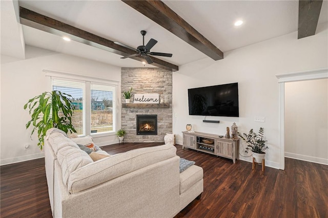 living room featuring a fireplace, beam ceiling, dark wood-type flooring, and ceiling fan