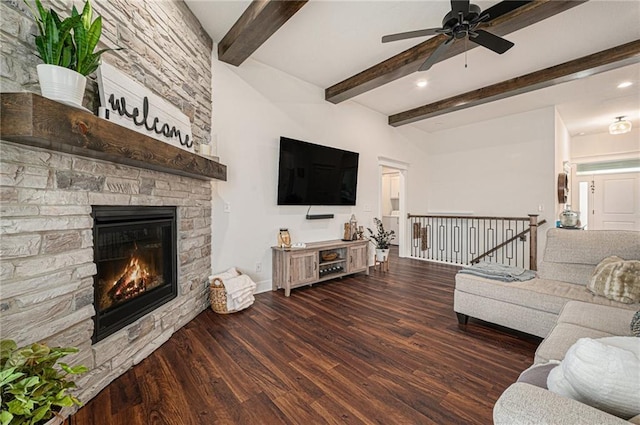 living room with beamed ceiling, ceiling fan, dark wood-type flooring, and a fireplace