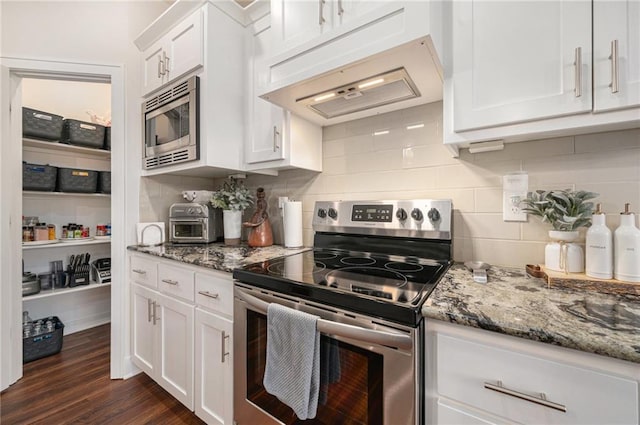 kitchen featuring white cabinetry, appliances with stainless steel finishes, stone counters, and premium range hood