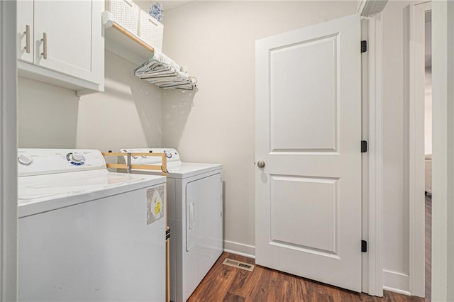 clothes washing area featuring independent washer and dryer, cabinets, and dark wood-type flooring