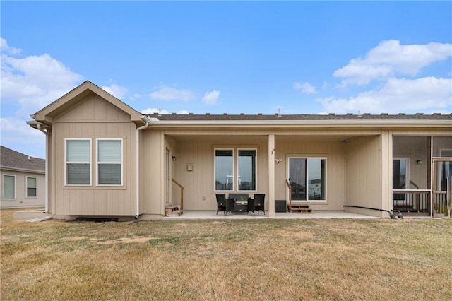 back of property with a yard and a patio