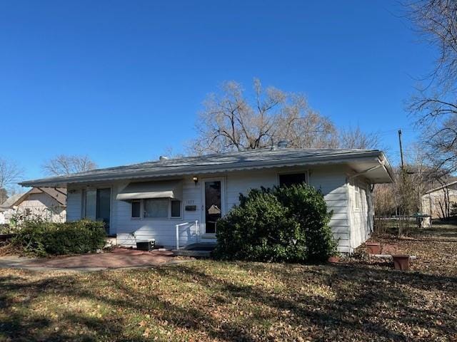 rear view of property with a lawn and a patio