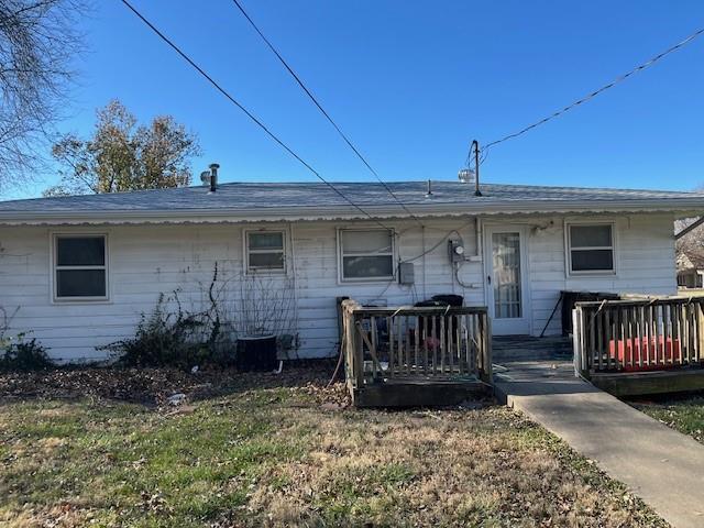 rear view of property with a deck and a lawn