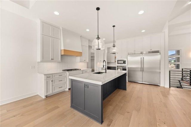 17021 Parkhill St, Overland Park, KS 66221 - kitchen with built in appliances, premium range hood, white cabinetry, light wood-style flooring, and decorative backsplash
