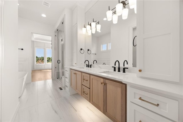 17021 Parkhill St, Overland Park, KS 66221 - bathroom with healthy amount of natural light, double vanity, a freestanding bath, marble finish flooring, and recessed lighting