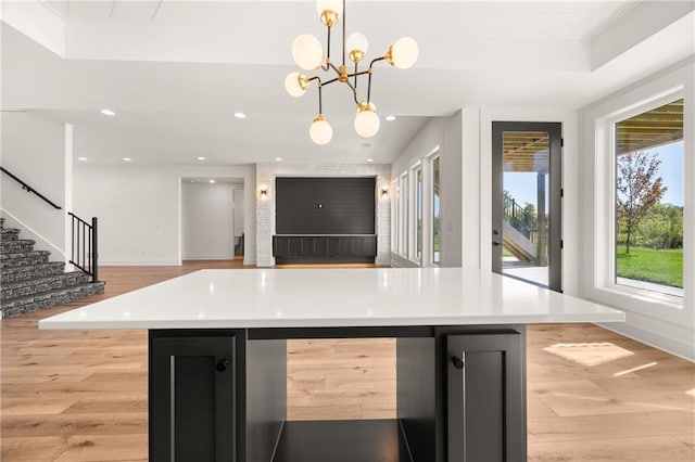 17021 Parkhill St, Overland Park, KS 66221 - kitchen with light wood finished floors, light countertops, dark cabinetry, decorative light fixtures, and recessed lighting