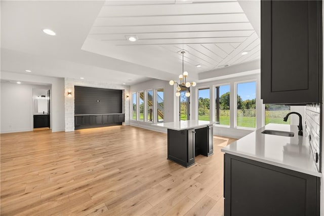 17021 Parkhill St, Overland Park, KS 66221 - kitchen with dark cabinets, light countertops, a tray ceiling, plenty of natural light, and recessed lighting