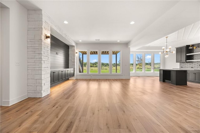 17021 Parkhill St, Overland Park, KS 66221 - unfurnished living room with a chandelier, light wood-style floors, and recessed lighting