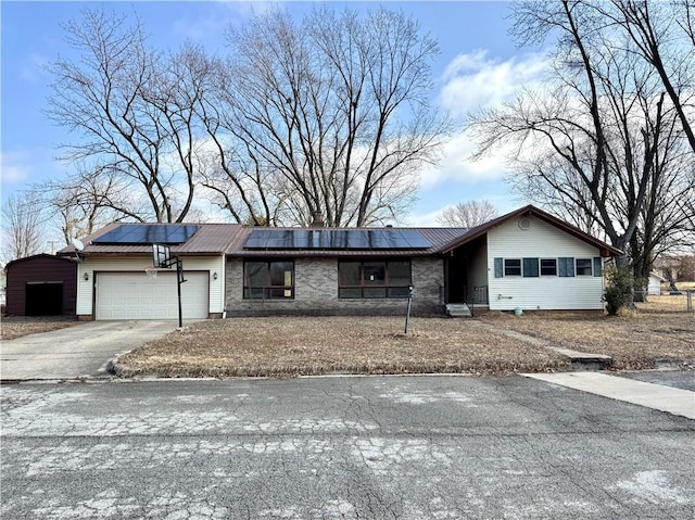 single story home with a garage and solar panels