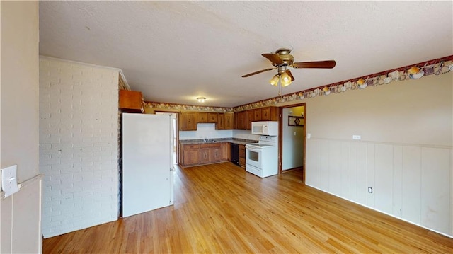 kitchen with brick wall, white appliances, ceiling fan, a textured ceiling, and light hardwood / wood-style flooring