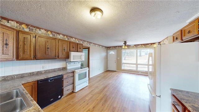 kitchen featuring sink, white appliances, ceiling fan, light hardwood / wood-style floors, and a textured ceiling