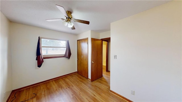 unfurnished bedroom featuring ceiling fan, light wood-type flooring, and a closet