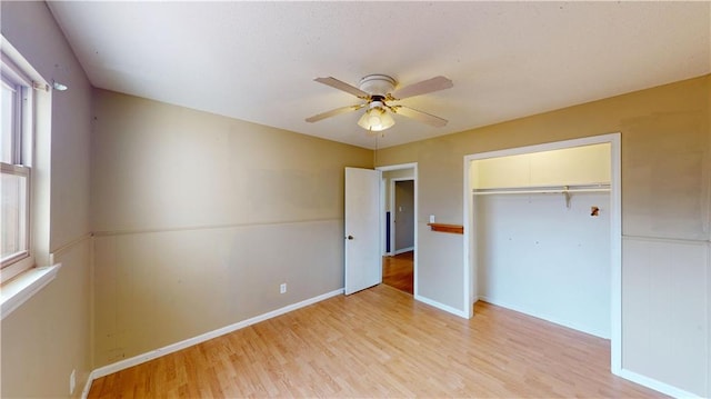 unfurnished bedroom with light hardwood / wood-style flooring, a closet, and ceiling fan