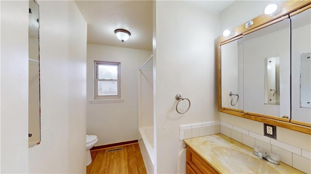 bathroom with vanity, a shower, wood-type flooring, and toilet