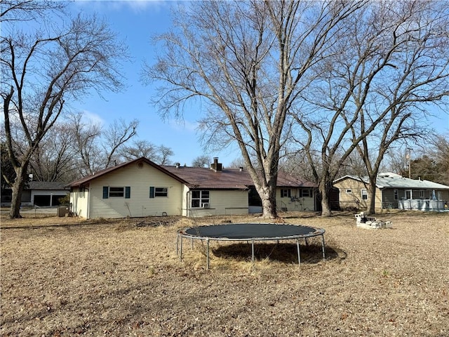 rear view of property featuring a trampoline