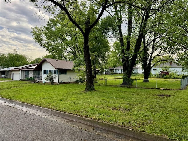 1120 N Oak St, Nevada, MO 64772 - exterior space with a garage, fence, and a front lawn