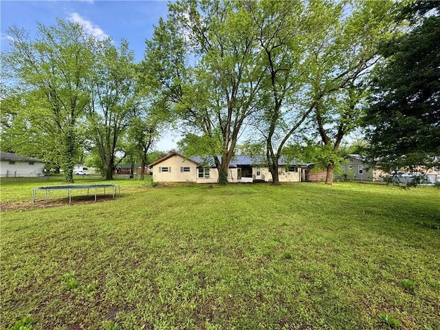 1120 N Oak St, Nevada, MO 64772 - view of yard featuring fence and a trampoline
