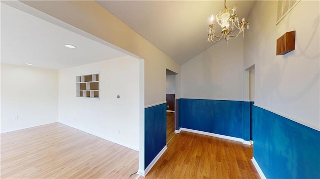 1120 N Oak St, Nevada, MO 64772 - empty room featuring an inviting chandelier, recessed lighting, baseboards, wood finished floors, and vaulted ceiling