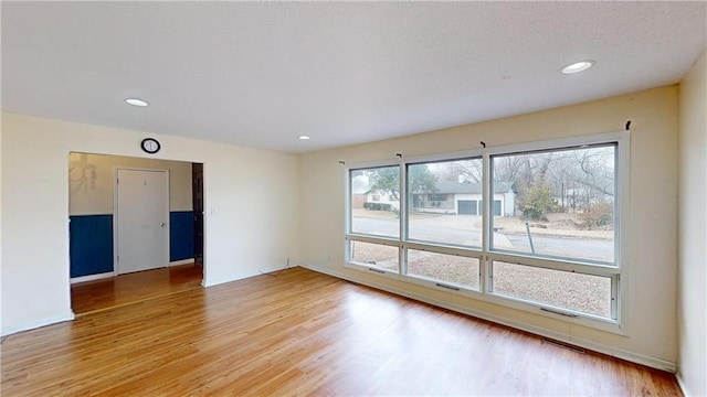 1120 N Oak St, Nevada, MO 64772 - empty room with baseboards, recessed lighting, light wood-style flooring, and visible vents