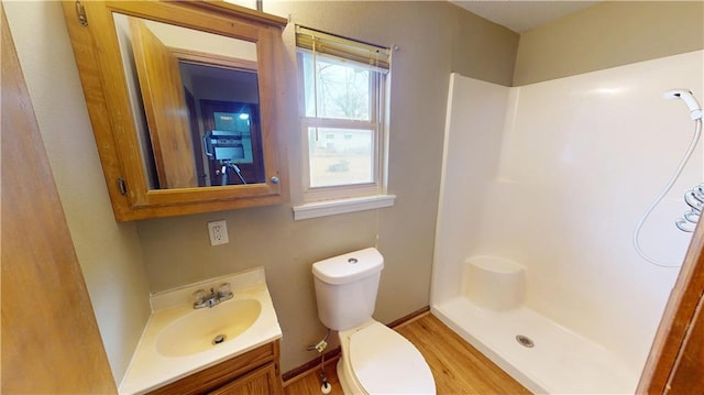 1120 N Oak St, Nevada, MO 64772 - bathroom featuring vanity, walk in shower, wood finished floors, and toilet