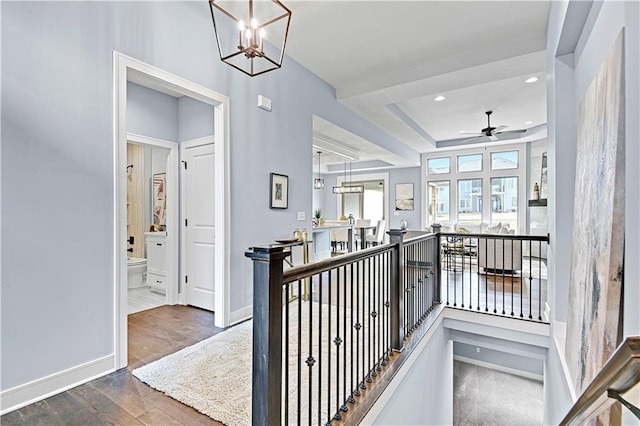 hallway with recessed lighting, baseboards, an upstairs landing, and wood finished floors