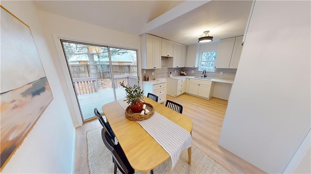 dining room with sink and light wood-type flooring