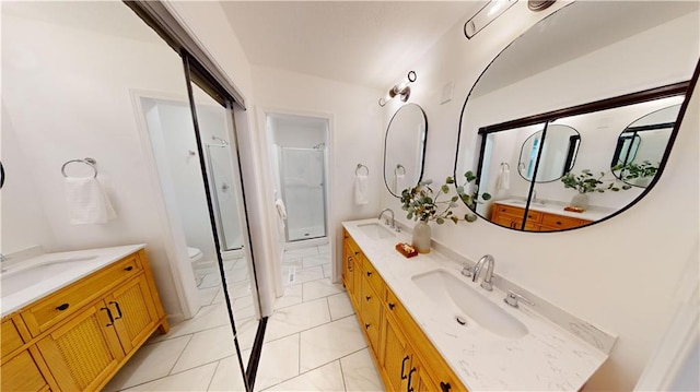 bathroom with vanity, toilet, tile patterned flooring, and a shower with door