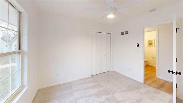 carpeted spare room featuring ceiling fan