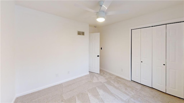 unfurnished bedroom with light carpet, a closet, and ceiling fan