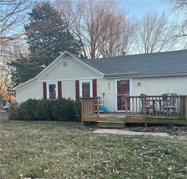 view of front of property with a deck and a front lawn