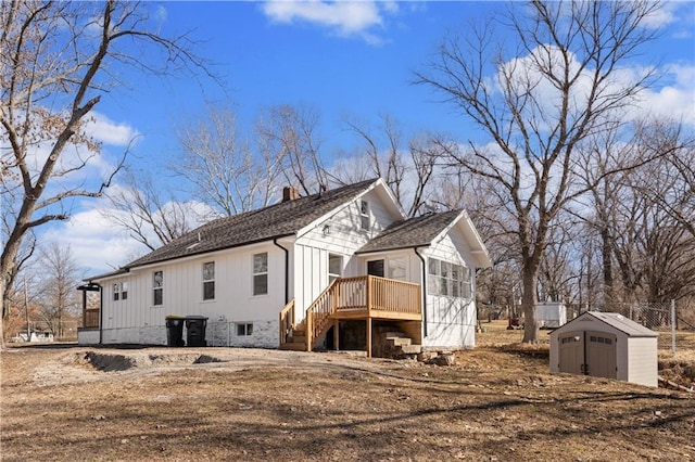 view of home's exterior featuring an outbuilding, roof with shingles, a chimney, a storage shed, and a deck