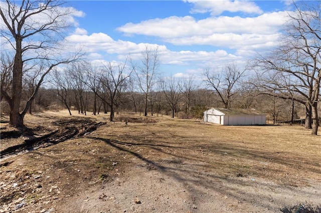 view of yard with a garage, a rural view, and an outdoor structure