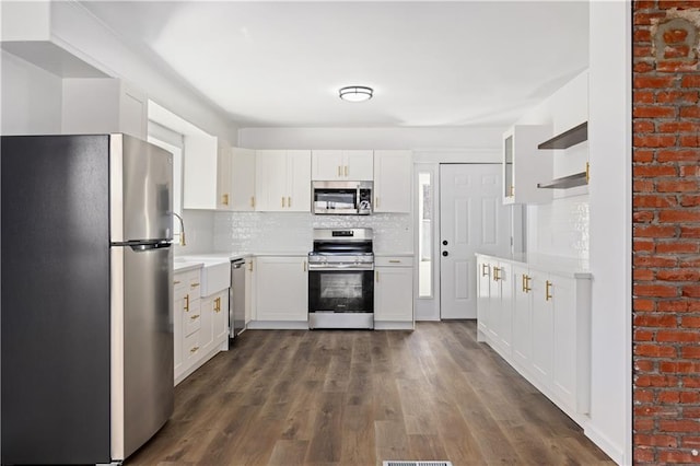 kitchen featuring appliances with stainless steel finishes, light countertops, decorative backsplash, and open shelves