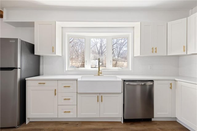 kitchen with stainless steel appliances, a sink, white cabinetry, and a healthy amount of sunlight