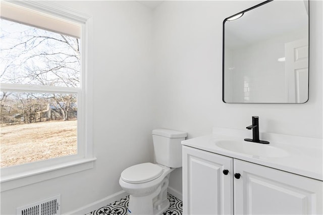 bathroom featuring baseboards, visible vents, vanity, and toilet