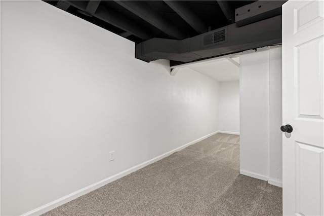 basement with visible vents, baseboards, and carpet flooring