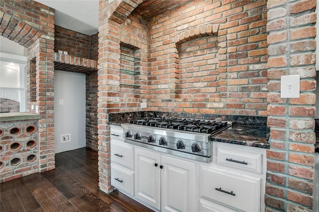 4300 SE Willow Ridge Dr, Blue Springs, MO 64014 - kitchen featuring brick wall, white cabinets, dark hardwood / wood-style flooring, dark stone counters, and stainless steel gas cooktop
