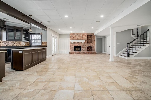 4300 SE Willow Ridge Dr, Blue Springs, MO 64014 - unfurnished living room with a paneled ceiling, a brick fireplace, and light tile patterned floors
