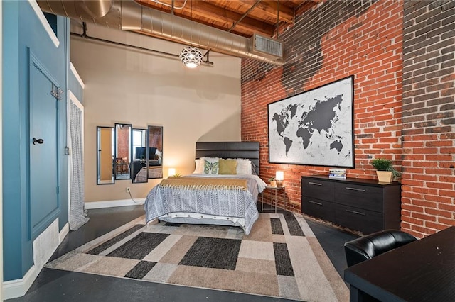 bedroom featuring wood ceiling, a towering ceiling, and brick wall