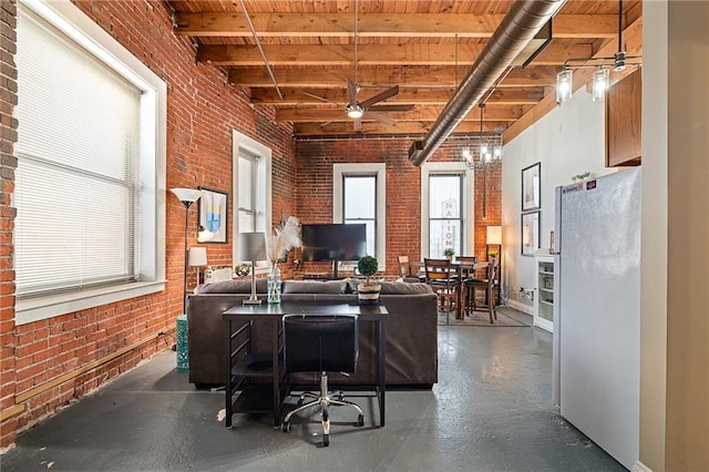 office space featuring a high ceiling, brick wall, and ceiling fan with notable chandelier