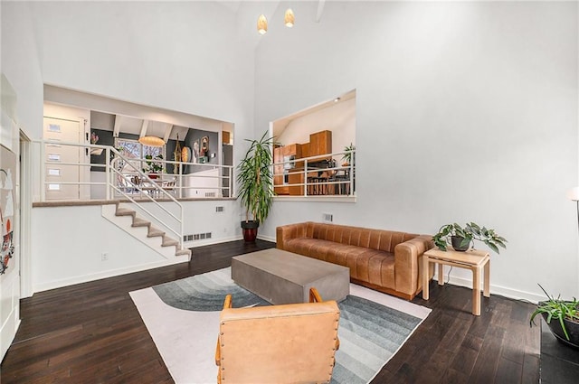 living room featuring dark wood-type flooring, stairway, and baseboards