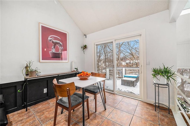 tiled dining space with lofted ceiling