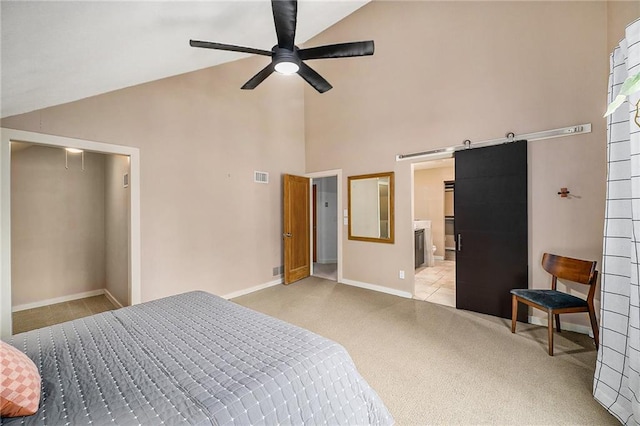 bedroom with light colored carpet, visible vents, a barn door, high vaulted ceiling, and baseboards