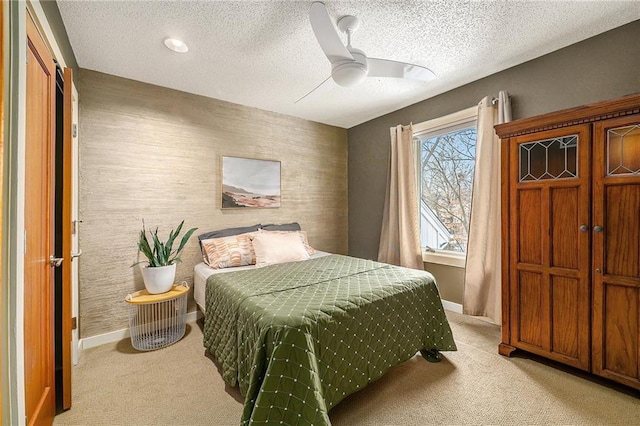 bedroom with baseboards, a textured ceiling, and light colored carpet